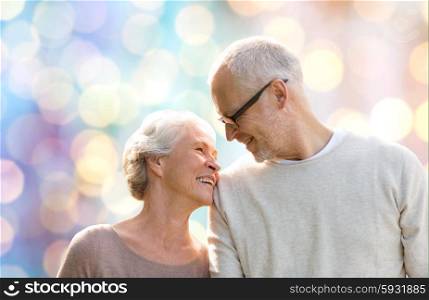 family, age, love, relations and people concept - happy senior couple over holidays lights background
