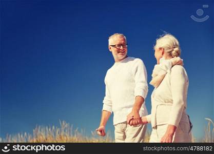 family, age, romance, leisure and people concept - happy senior couple holding hands and talking outdoors