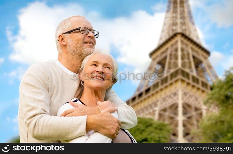 family, age, tourism, travel and people concept - happy senior couple hugging over paris eiffel tower in france