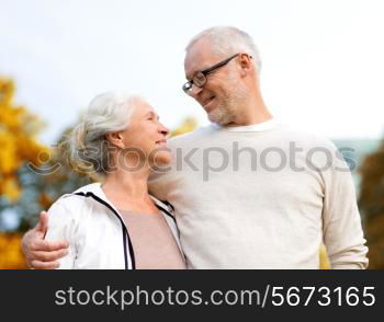 family, age, tourism, travel and people concept - senior couple hugging in city park