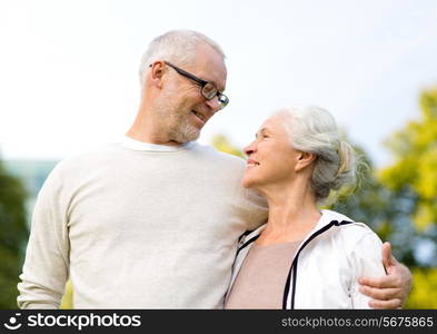 family, age, tourism, travel and people concept - senior couple hugging in city park