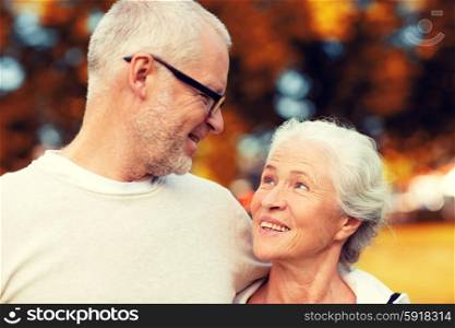 family, age, tourism, travel and people concept - senior couple hugging in city park