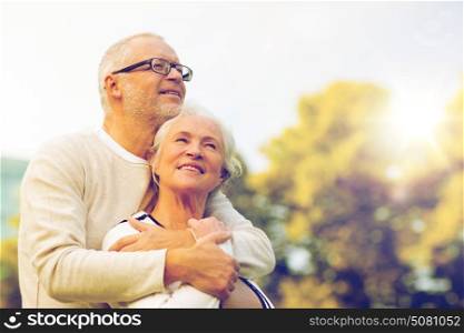 family, age, tourism, travel and people concept - senior couple hugging in park. senior couple hugging in park