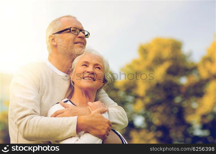 family, age, tourism, travel and people concept - senior couple hugging in park