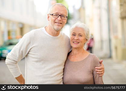 family, age, tourism, travel and people concept - senior couple hugging on city street