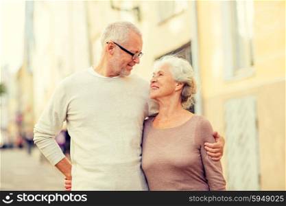 family, age, tourism, travel and people concept - senior couple hugging on city street