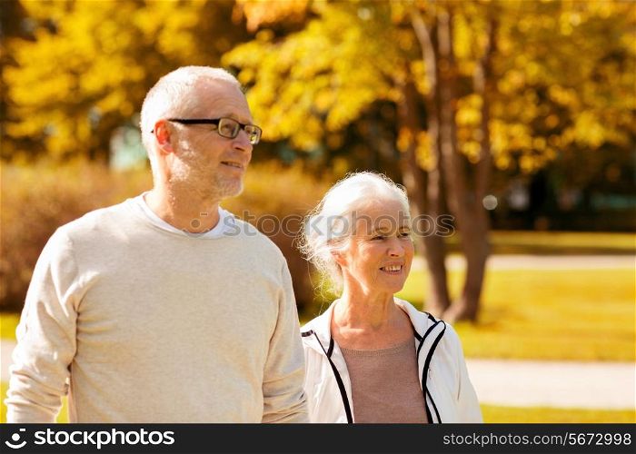 family, age, tourism, travel and people concept - senior couple walking in city park