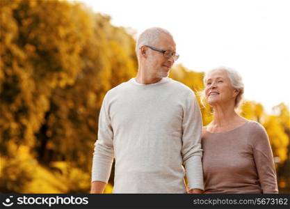 family, age, tourism, travel and people concept - senior couple walking in park