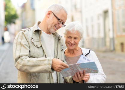 family, age, tourism, travel and people concept - senior couple with map and city guide on street