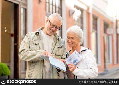 family, age, tourism, travel and people concept - senior couple with map and city guide on street