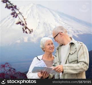 family, age, tourism, travel and people concept - senior couple with map and city guide over japan mountains background