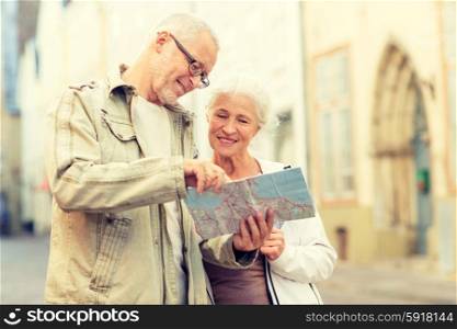 family, age, tourism, travel and people concept - senior couple with map and city guide on street