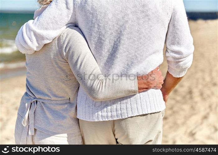 family, age, travel, tourism and people concept - close up of happy senior couple hugging on summer beach