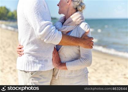 family, age, travel, tourism and people concept - close up of happy senior couple hugging on summer beach