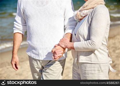 family, age, travel, tourism and people concept - close up of senior couple walking on summer beach