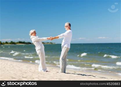 family, age, travel, tourism and people concept - happy senior couple holding hands and dancing on summer beach