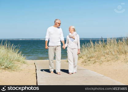 family, age, travel, tourism and people concept - happy senior couple holding hands and walking on summer beach