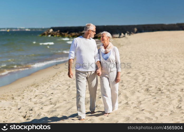 family, age, travel, tourism and people concept - happy senior couple holding hands and walking on summer beach