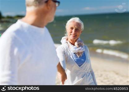 family, age, travel, tourism and people concept - happy senior couple holding hands on summer beach