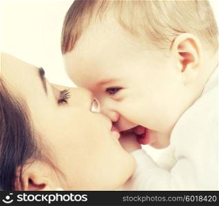 family and happy people concept - mother kissing her baby. mother kissing her baby