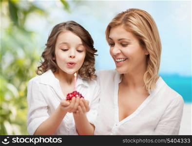 family and holidays concept - happy mother and daughter with birthday cake