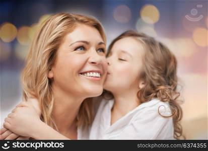 family and motherhood concept - happy mother and daughter hugging and kissing over holidays lights background. happy mother with daughter hugging and kissing