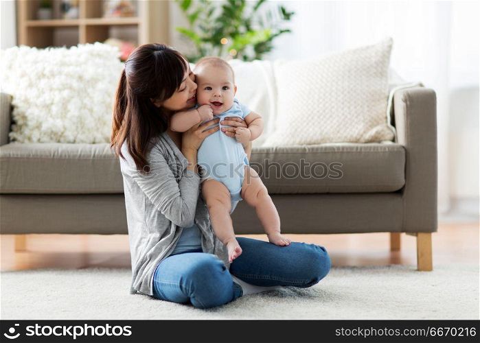 family and motherhood concept - happy smiling young asian mother with little baby at home. happy young mother with little baby at home. happy young mother with little baby at home