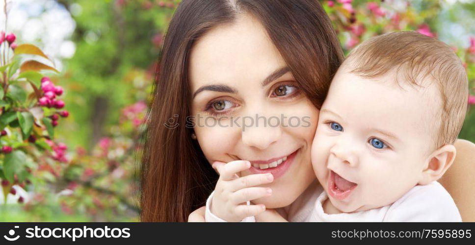 family and motherhood concept - happy smiling young mother with little baby over natural spring cherry blossom background. mother with baby over spring garden background