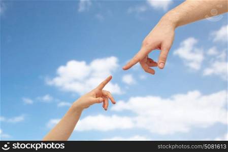 family and people concept - father and child hands pointing fingers to each other over blue sky and clouds background. father and child hands pointing fingers