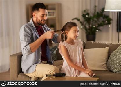 family and people concept - happy father braiding daughter hair at home. father braiding daughter hair at home