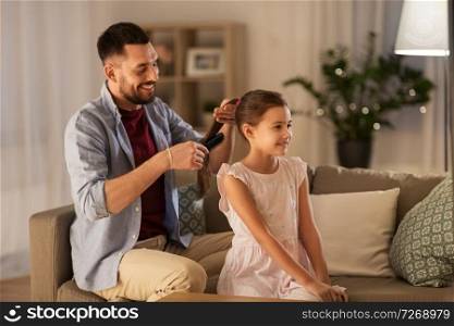 family and people concept - happy father brushing daughter hair at home. father brushing daughter hair at home