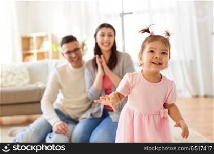 family and people concept - happy little daughter with mother and father at home. happy baby girl and parents at home. happy baby girl and parents at home