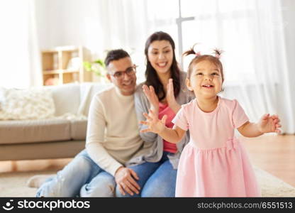 family and people concept - happy little daughter with mother and father at home. happy baby girl and parents at home. happy baby girl and parents at home