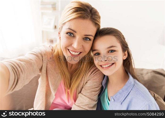 family and people concept - happy mother and daughter taking selfie at home. happy family taking selfie at home. happy family taking selfie at home