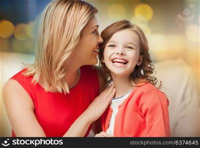 family and people concept - happy mother and daughter whispering something into ear over festive lights background. happy mother and girl whispering into ear