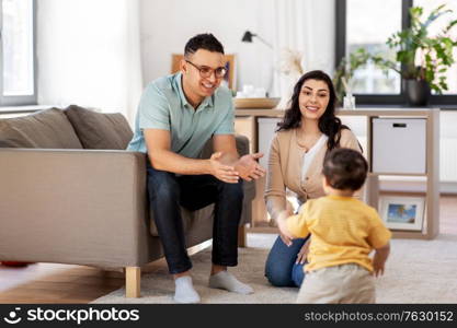 family and people concept - happy mother, father and baby son at home. happy family with child at home