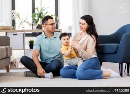 family and people concept - happy mother, father and baby son sitting on floor at home. happy family with child sitting on floor at home