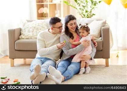 family and people concept - happy mother, father and little daughter at home. baby girl with parents at home. baby girl with parents at home