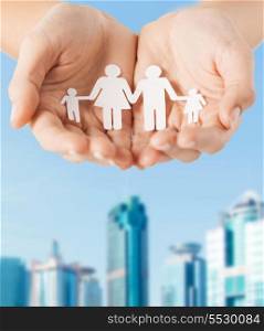 family and relations concept - close up of female cupped hands showing paper man family