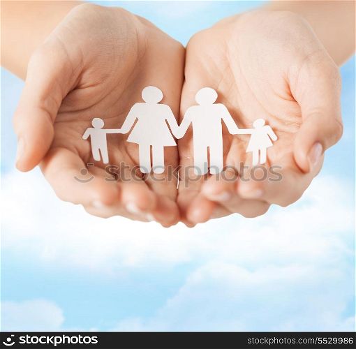 family and relations concept - closeup of female cupped hands showing paper man family