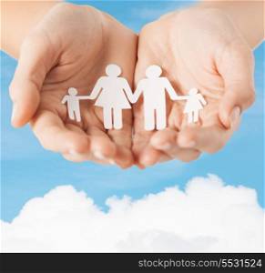 family and relations concept - closeup of female cupped hands showing paper man family
