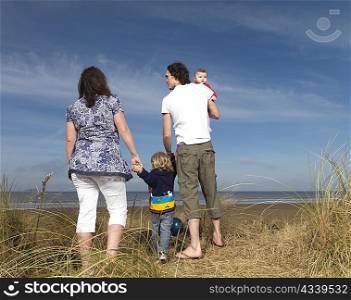 family at beach looking out to sea