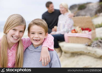 Family at beach with picnic smiling