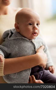 family, babyhood and people concept - close up of mother holding little baby boy in cardigan. close up of mother with little baby in cardigan