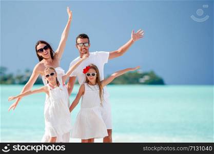 Family beach vacation on caribbean island. Happy beautiful family of four on the beach