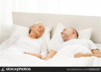 family, bedtime, resting, age and people concept - happy senior couple lying in bad at home