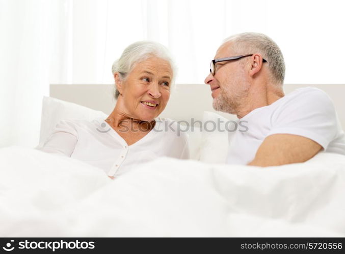 family, bedtime, resting, age and people concept - happy senior coupler lying in bad at home