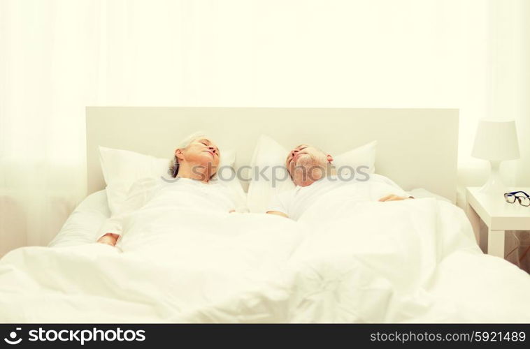 family, bedtime, resting, age and people concept - happy senior coupler lying in bad at home