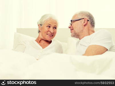 family, bedtime, resting, age and people concept - happy senior coupler lying in bad at home