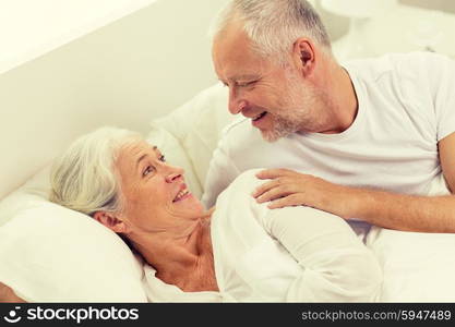 family, bedtime, resting, age and people concept - happy senior coupler lying in bad at home